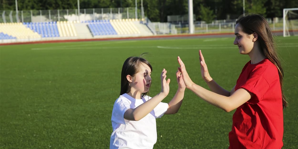 Teacher with a student at a sports field