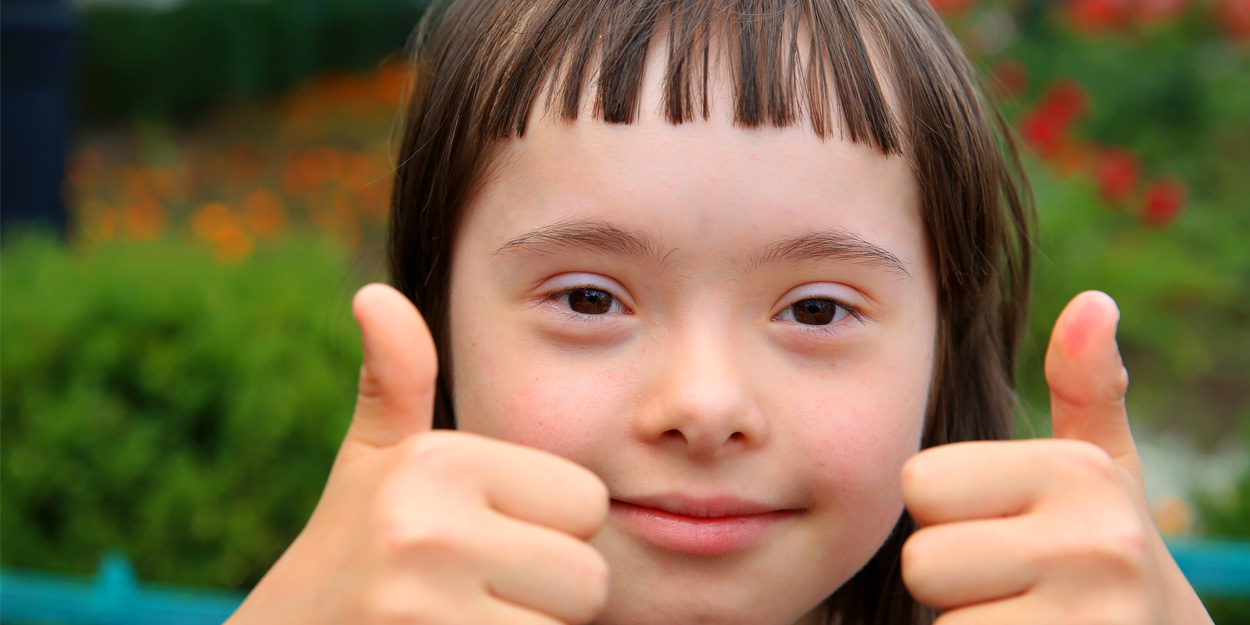 A face of an school girl showing her thumbs up