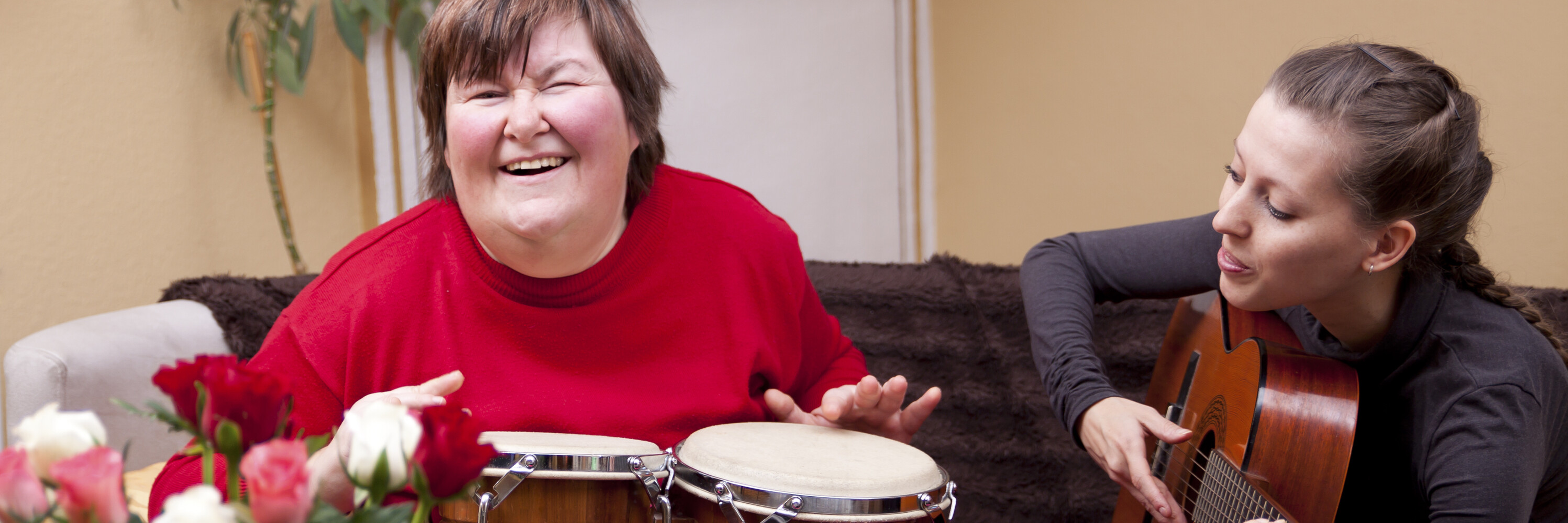 Student playing the drums and a teacher playing the guitar during music class